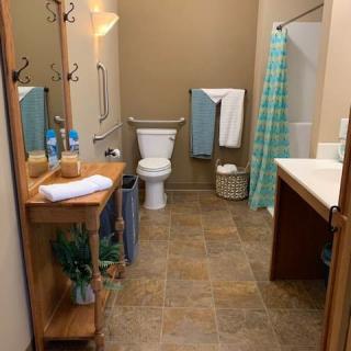 A neatly organized bathroom with a shower, toilet, and sink.