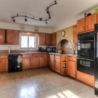Spacious kitchen with wooden cabinets and modern appliances.