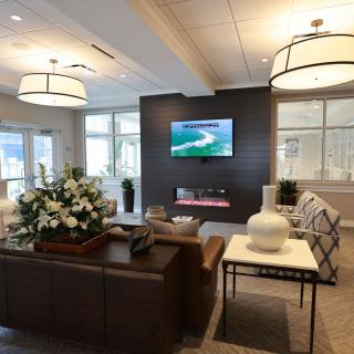 A modern living room with stylish furniture and a mounted television.