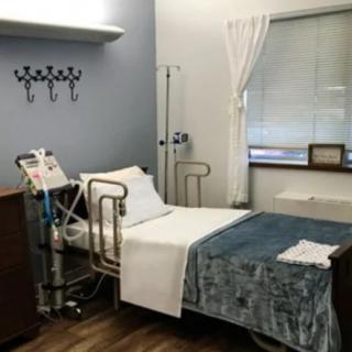 A clean and minimalist hospital room with essential medical equipment beside the bed.