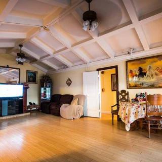 A cozy living room with comfortable furniture, a large TV, and artwork on the walls.