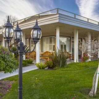A modern house with a well-maintained garden and distinctive lamp posts.