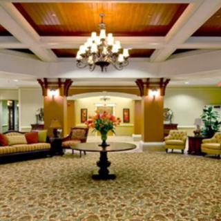 Elegant hotel lobby with a central table and chandelier.