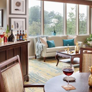 Cozy living space with a bar area and large windows allowing natural light.