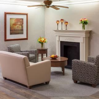A cozy living room featuring stylish furniture, a fireplace, and decorative flowers.