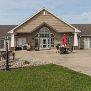 A inviting residential building with a patio area and well-maintained lawn.