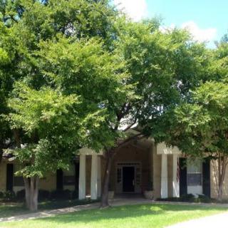 A suburban house with a tree-lined entrance.