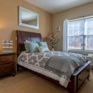 A cozy bedroom with a neatly made bed and warm lighting.