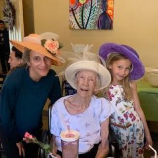 A joyful family gathering with three people wearing colorful hats.