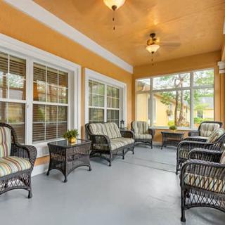 Cozy sunroom with wicker furniture and large windows.