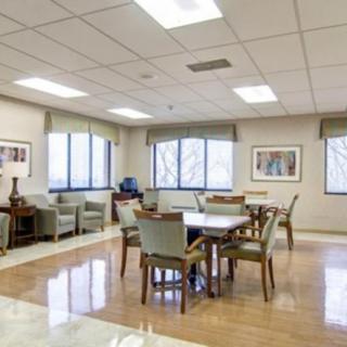 A well-lit meeting room with tables and chairs arranged in a spacious layout.
