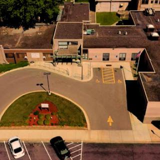 An aerial view of a building with a circular driveway and parking lot.
