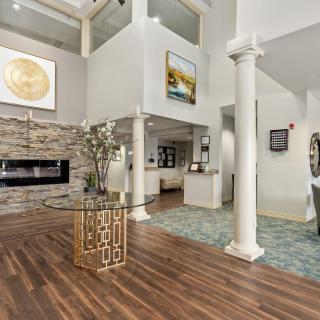 A modern living room with a fireplace, elegant wood flooring, and stylish artwork.