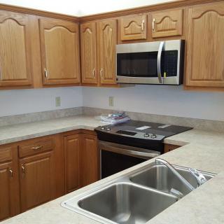 A modern kitchen with wooden cabinets and stainless steel appliances.