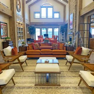 A spacious and brightly lit living room with modern furniture and a warm color palette.