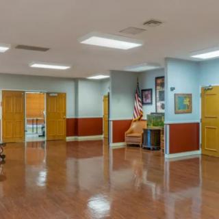 An empty hallway with wooden doors, chairs, and wall decorations.