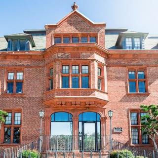 A historic brick building with large windows and ornate architectural details.
