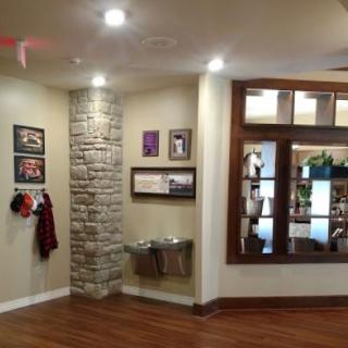 A cozy waiting area with a stone accent wall, hardwood flooring, and water fountains.