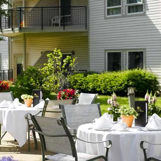 An inviting outdoor dining area with tables set among lush greenery.