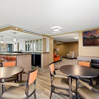A modern dining area with tables and chairs, featuring bright lighting and contemporary decor.