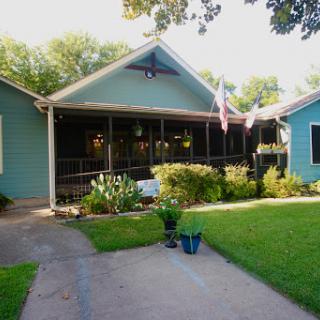 A charming blue house with a welcoming porch and well-maintained garden.