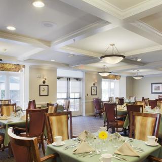 A well-lit dining room with multiple tables set for a meal.
