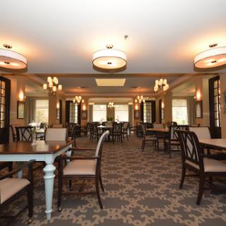 A spacious and elegantly designed dining room with stylish furniture and warm lighting.