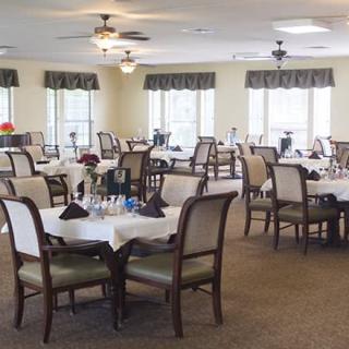 An empty dining room with neatly arranged tables and chairs, ready for guests.
