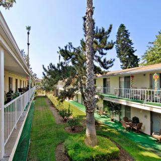 A view of a two-story apartment building with balconies overlooking a landscaped courtyard.