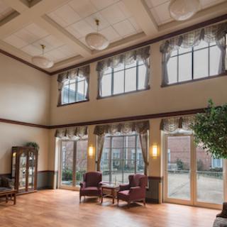 A spacious and inviting lobby area featuring large windows, comfortable seating, and a touch of greenery.