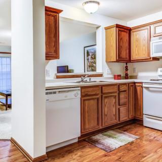 A cozy kitchen with wooden cabinets and white appliances.