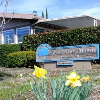Entrance sign for a senior living community with blooming daffodils in the foreground.