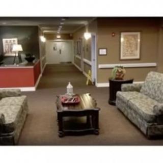 A cozy lobby area with sofas and a coffee table leading to a hallway.