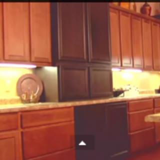 A kitchen with wooden cabinets and under-cabinet lighting.