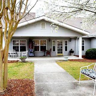 A quaint house with a welcoming front porch and well-maintained landscaping.