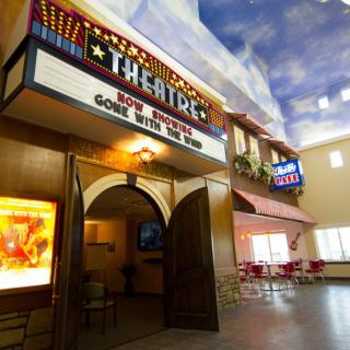 Entrance to a theater with a marquee displaying movie titles.