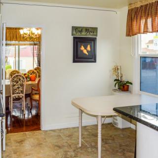 A view from a kitchen looking into a dining area, featuring a small table, chairs, and decor.