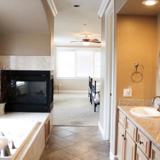 A modern bathroom with a tiled floor and neutral tones, featuring a bathtub and sink area.