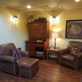 Cozy living room with leather furniture and warm lighting.