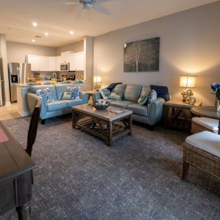 A modern, open-concept living room with a cozy seating area and adjoining kitchen.