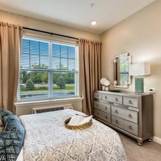 A tastefully decorated bedroom with a large window and elegant furnishings.