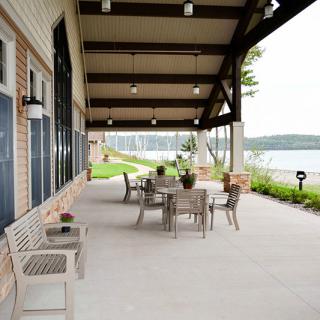 A serene patio with outdoor seating overlooking a lake.