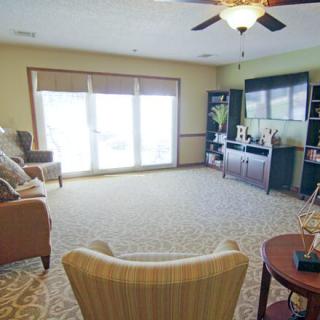 A cozy living room featuring a large window, comfortable seating, and a TV entertainment area.