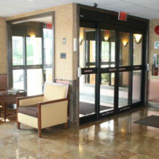 A clean and modern lobby with seating area and glass entrance doors.