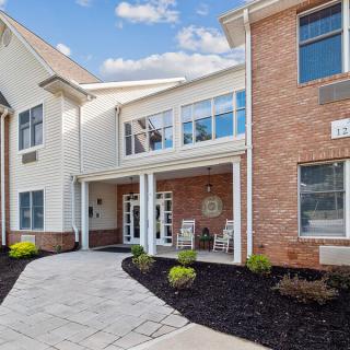 A modern residential building entrance with well-maintained landscaping.