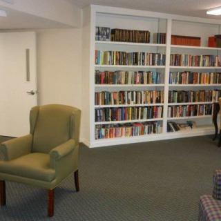 A cozy reading area with a bookshelf filled with books and a comfortable chair.