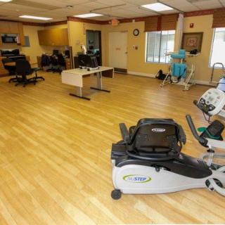 A spacious rehabilitation center featuring various exercise equipment for physical therapy.