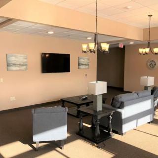 A cozy living room setting with sofas, a coffee table, and a wall-mounted television.