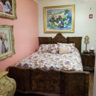 A cozy bedroom with vintage-style furniture and floral decor.