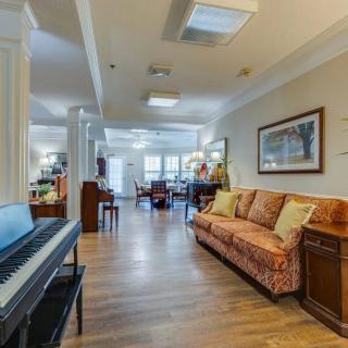 A spacious living room with a piano, sofa, and stylish decor.
